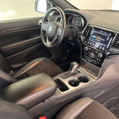 Interior view of a car showing dashboard, steering wheel, and console with cup holders.
